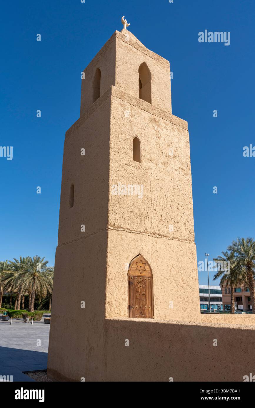 Nahaufnahme eines hohen Minaretts aus Lehmziegel mit Bogenfenstern und einer spitzen Spitze an der Qasr Al Muwaiji Moschee in Al Ain Vereinigte Arabische Emirate. Stockfoto
