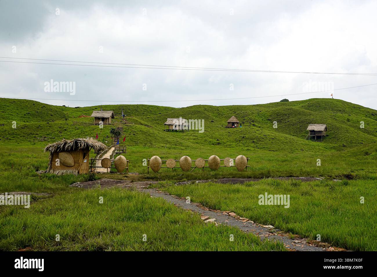 Diese malerische ländliche Landschaft bietet traditionelle Hütten, die über sanfte grüne Hügel verstreut sind. Stockfoto