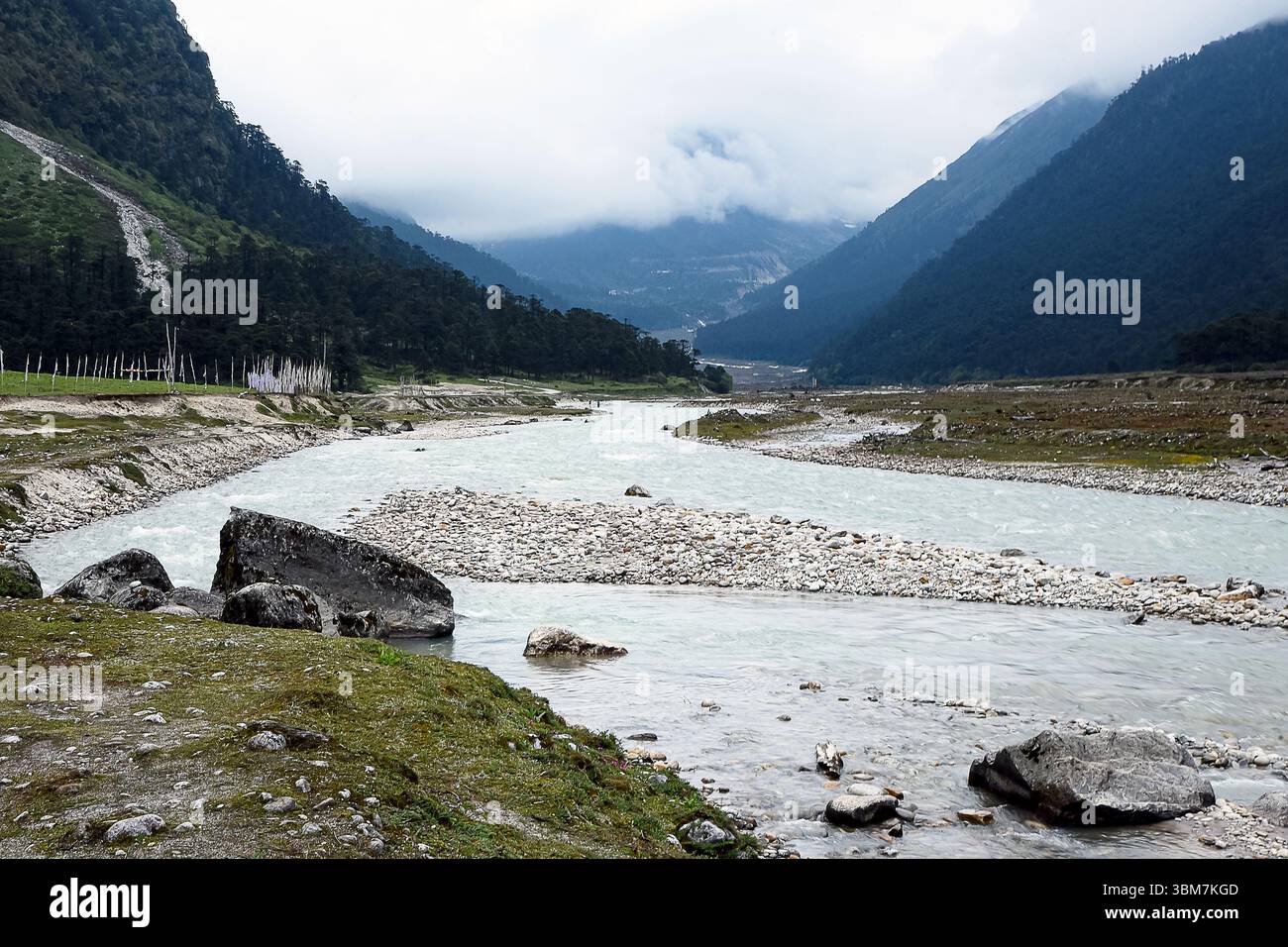Ein atemberaubender Blick auf das Yumthang Valley in North Sikkim, Indien, mit einem unberührten Bergfluss, der sich durch eine dramatische Himalaya-Landschaft schlängelt. Stockfoto