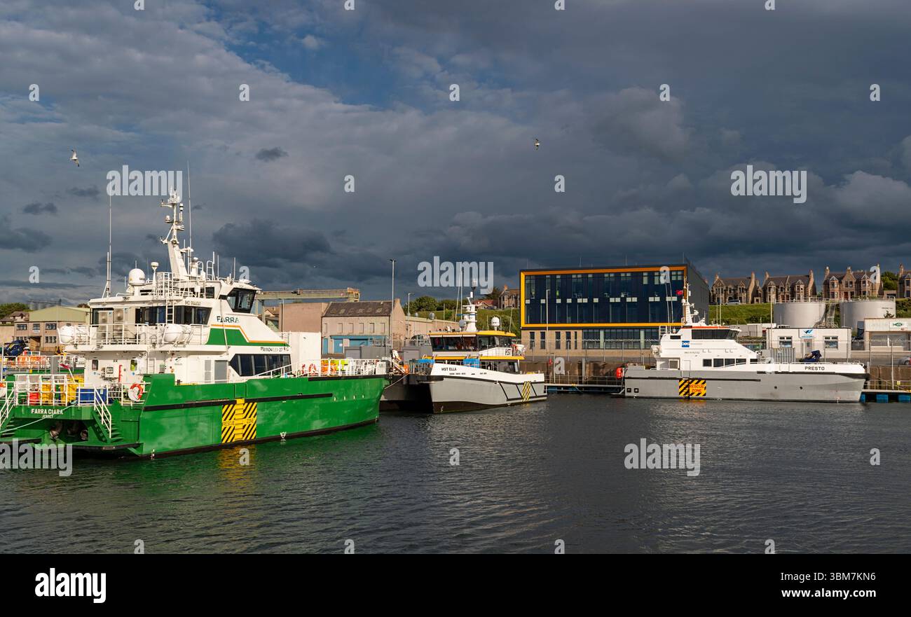 Buckie Harbour Moray Coast Scotland das Ocean Wave Gebäude und vertäute Windkraftanlagen-Serviceschiffe Stockfoto