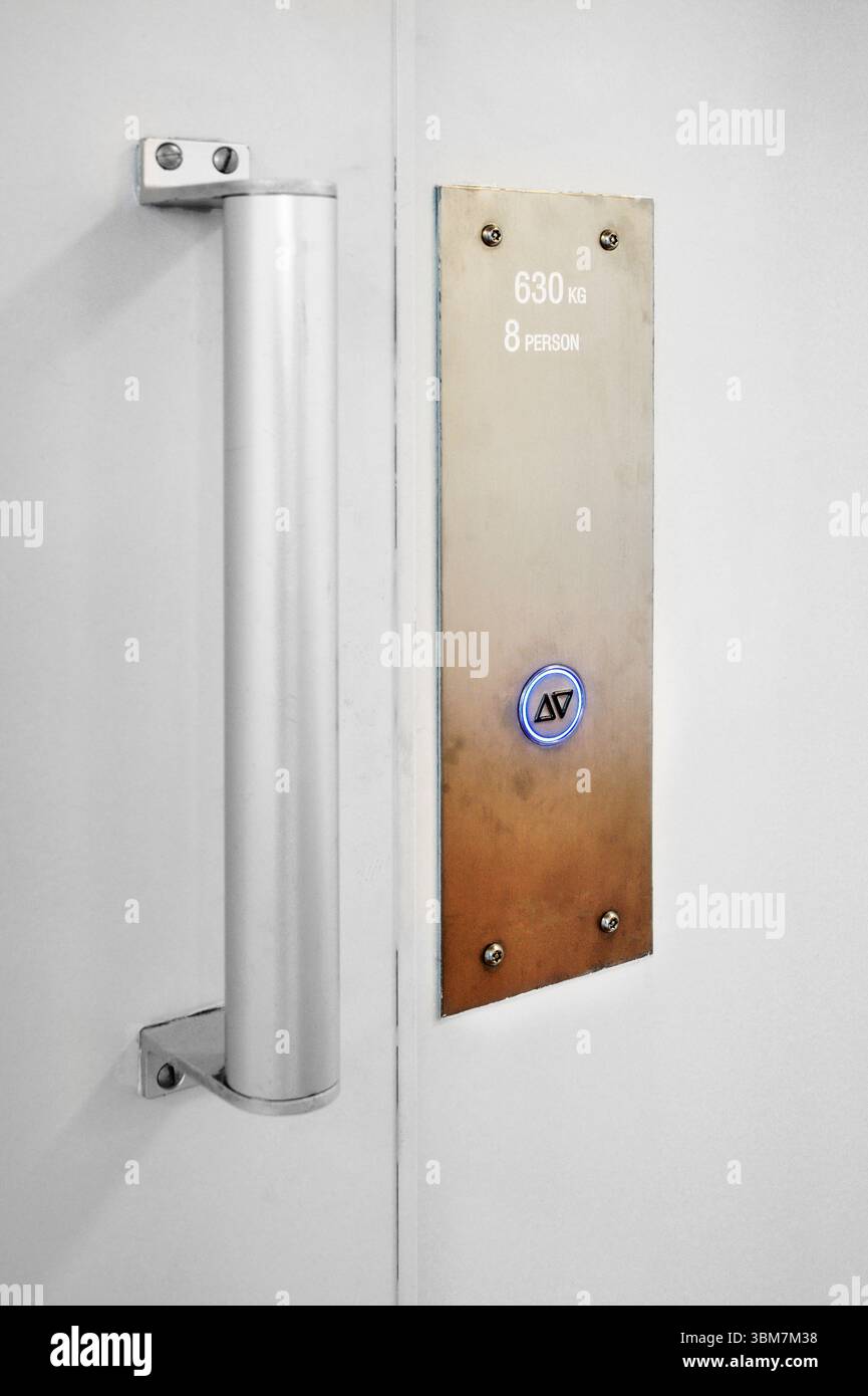 Fahrstuhlknopf an der weißen Wand. Fahrstuhltaste nach oben und unten mit Kopierraum Stockfoto