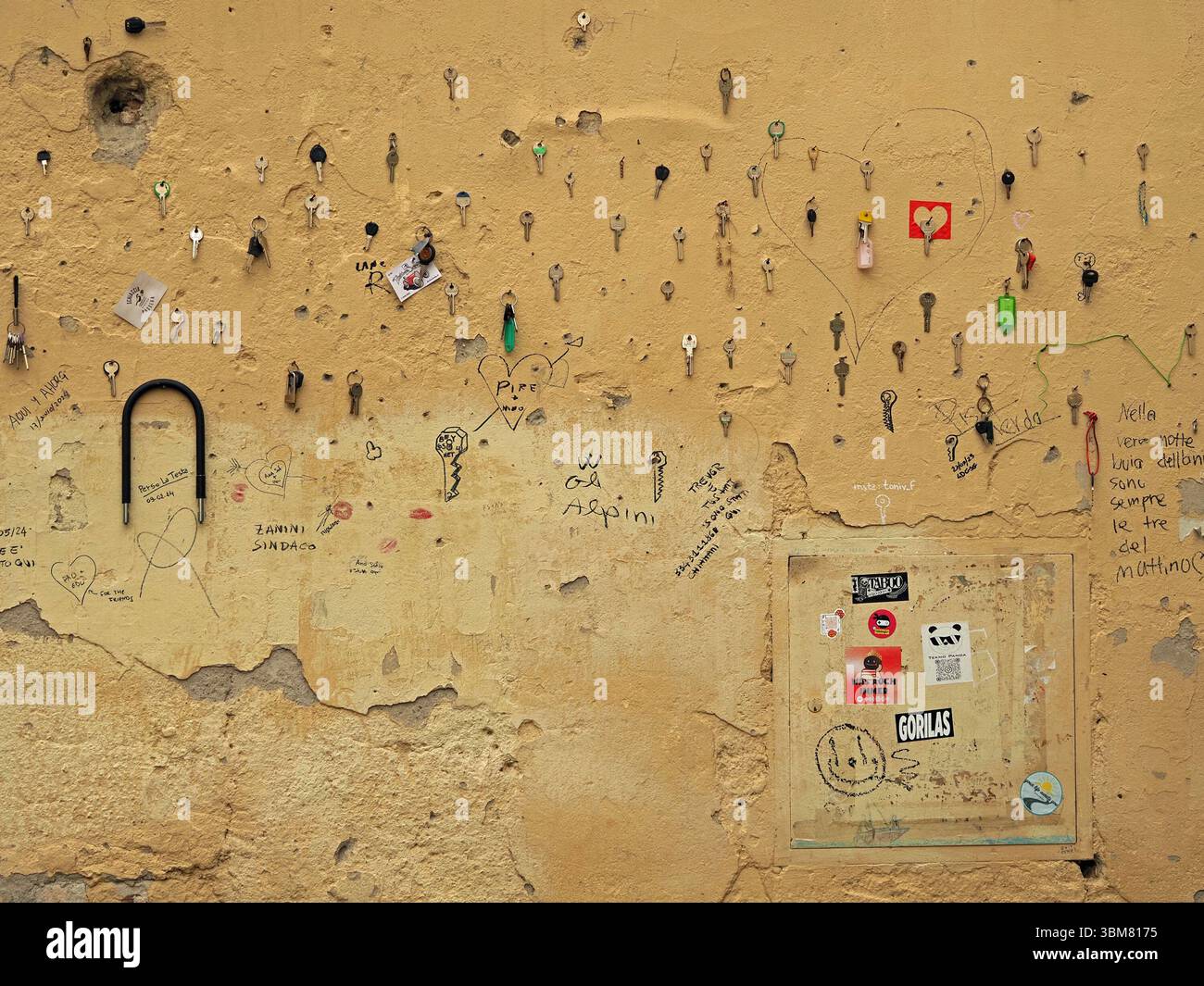 Viele Schlüssel wurden an der Wand des Gebäudes auf einer piazza in Florenz, Italien, mit Liebesbotschaften befestigt Stockfoto