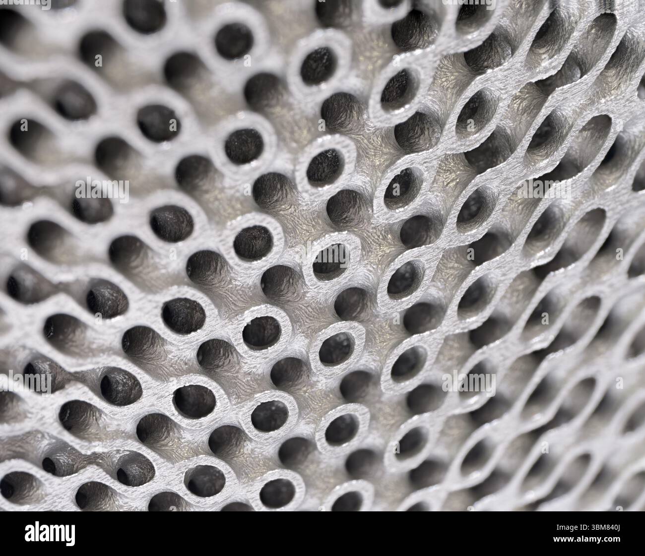 3D-gedrucktes Metallgitter, dreidimensionales durchbrochenes Gitterfenster aus Nahaufnahme. Abstrakter Hintergrund moderner Technologie. Stockfoto