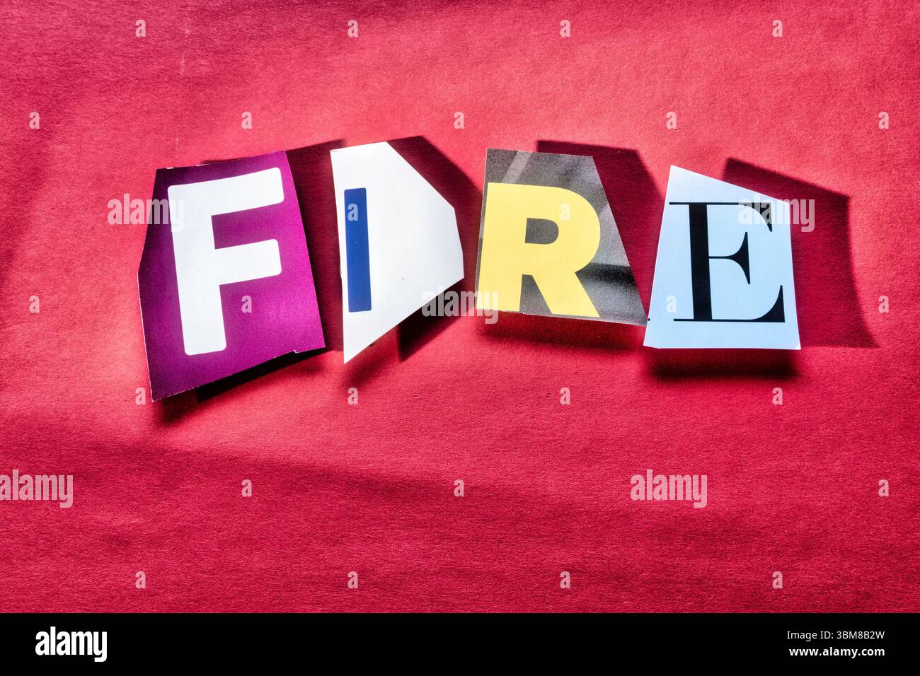 "FEUER" mit ausgeschnittenen Papierbuchstaben in der Lösegeldscheineffekt-Typografie, 2025 Stockfoto