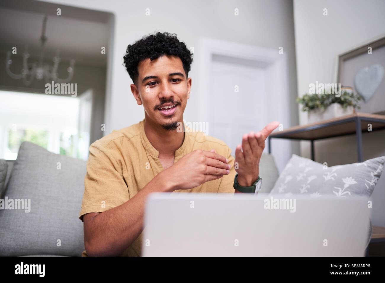 Person, die einen Videoanruf in einer angenehmen Umgebung zu Hause führt Stockfoto