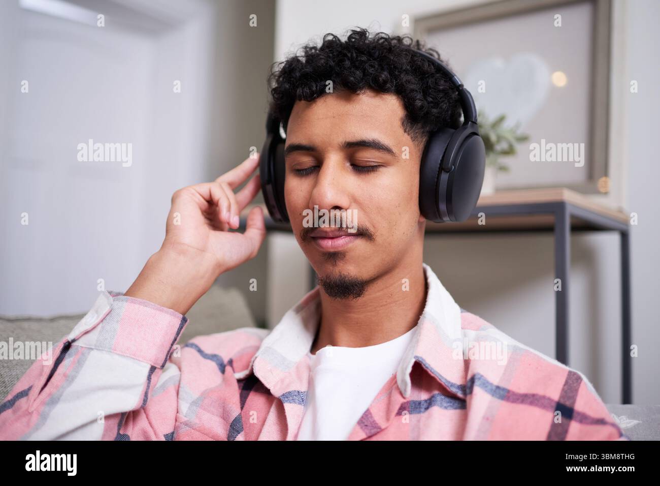 Dank schnurloser Kopfhörer mit Geräuschminimierung können Sie sich drinnen entspannen und Musik hören Stockfoto