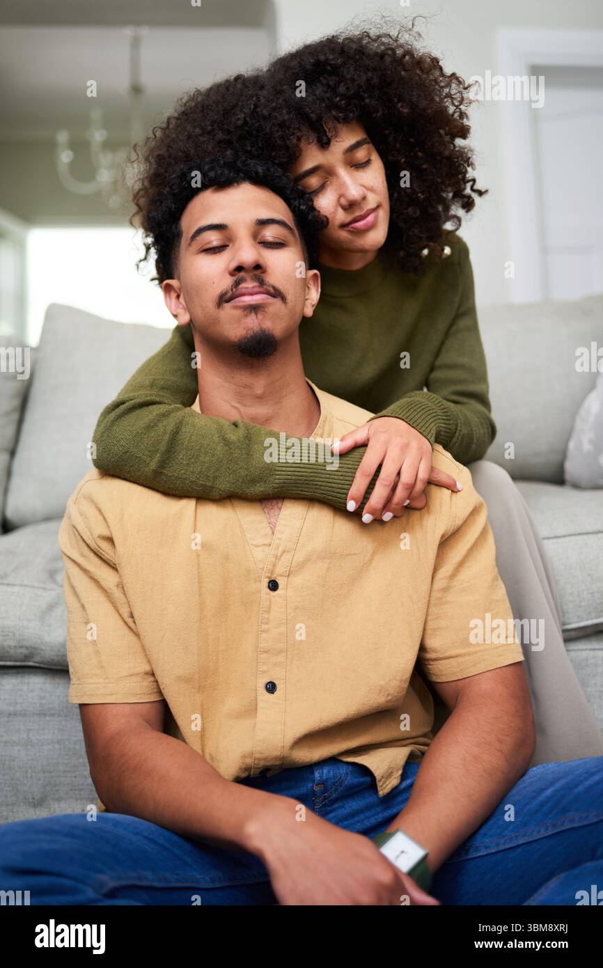 Glückliches Paar, das sich zu Hause in einem komfortablen Wohnzimmer entspannt Stockfoto