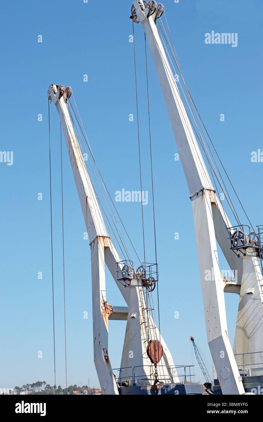 Hohe Kräne und unfertige Gebäude auf einer Baustelle in Porto, Portugal. Das Foto zeigt den Maßstab und die Geometrie des industriellen Fortschritts unter Stockfoto