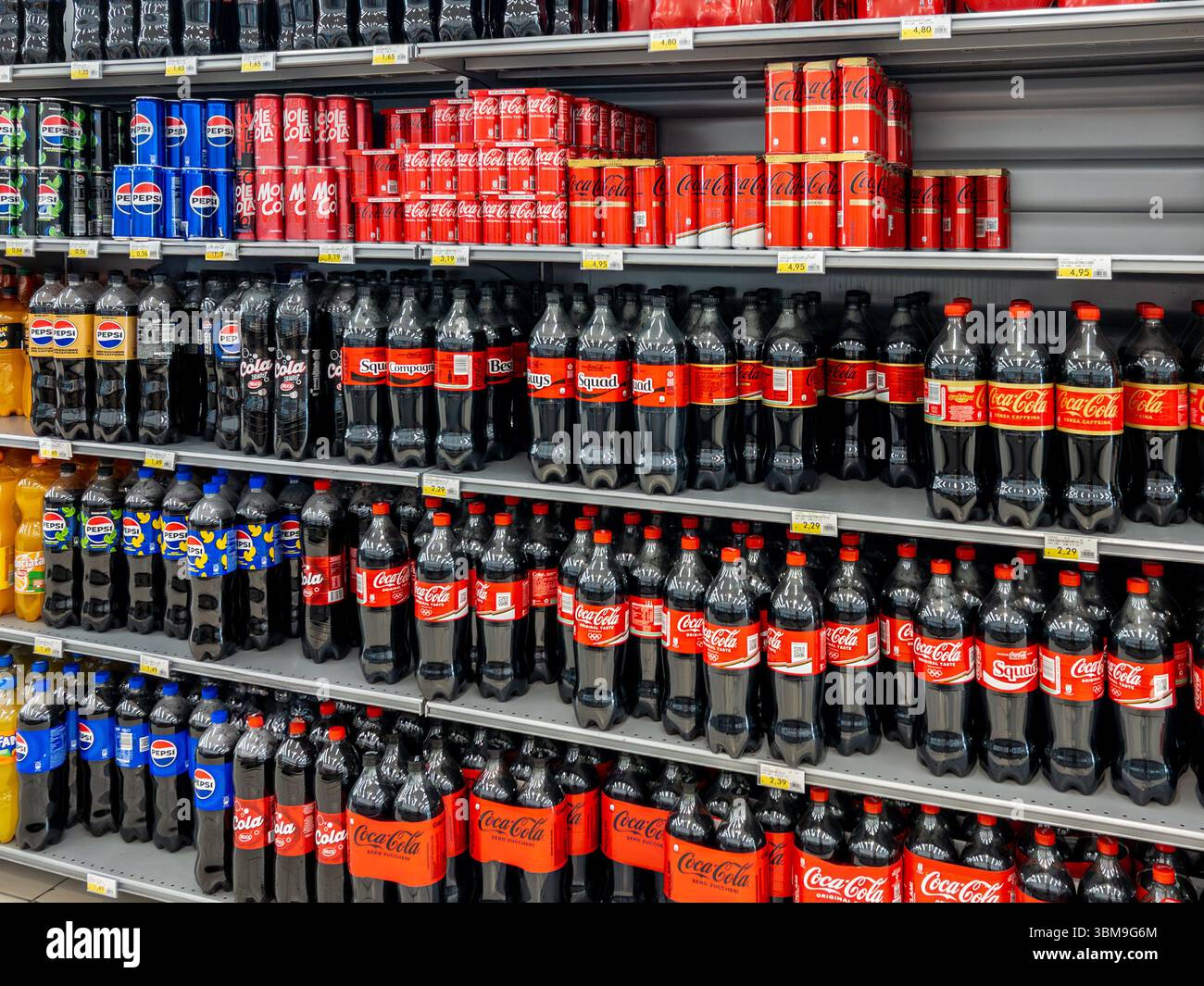 Italien - 25. Juni 2025: Cola und Pepsi Cola in Plastikflaschen und Dosen im Regal für den Verkauf im italienischen Supermarkt Stockfoto