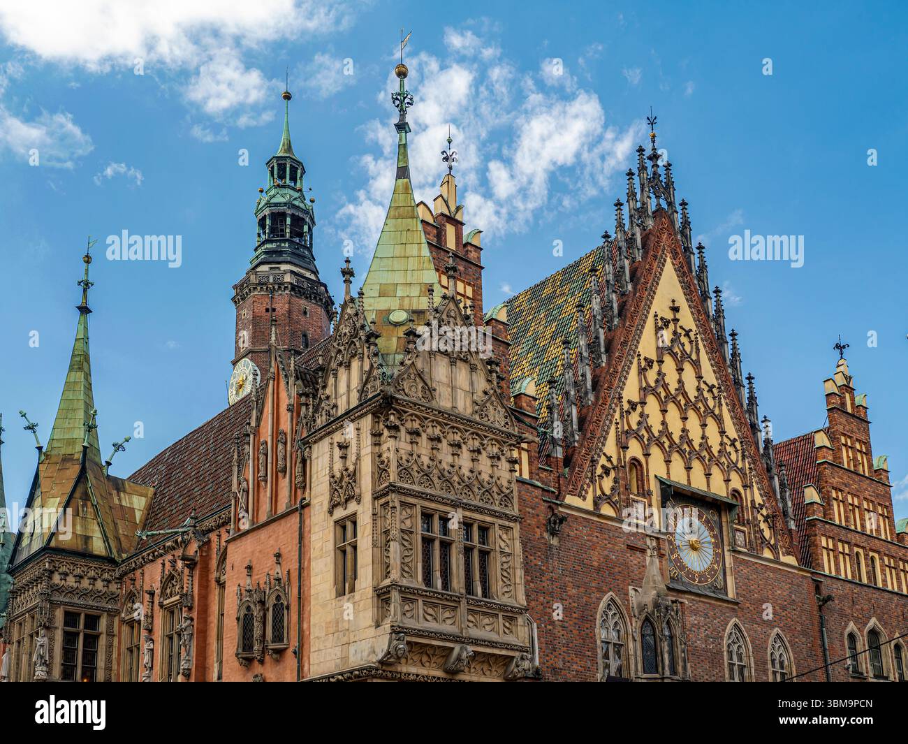 Ein beeindruckender Blick auf ein historisches Rathaus im gotischen Stil mit verzierten Details, Türmen und einer Uhr an einem sonnigen Tag mit klarem blauem Himmel, Breslau, Pola Stockfoto