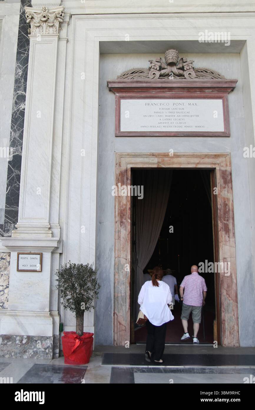 Menschenmassen gehen durch die Heilige Pforte (Porta Santa) der päpstlichen Basilika St. Paul vor den Mauern ist eine der vier wichtigsten päpstlichen Basiliken Roms. Die Türen werden nur alle 25 Jahre im Rahmen des Jubiläums in Rom geöffnet. Stockfoto