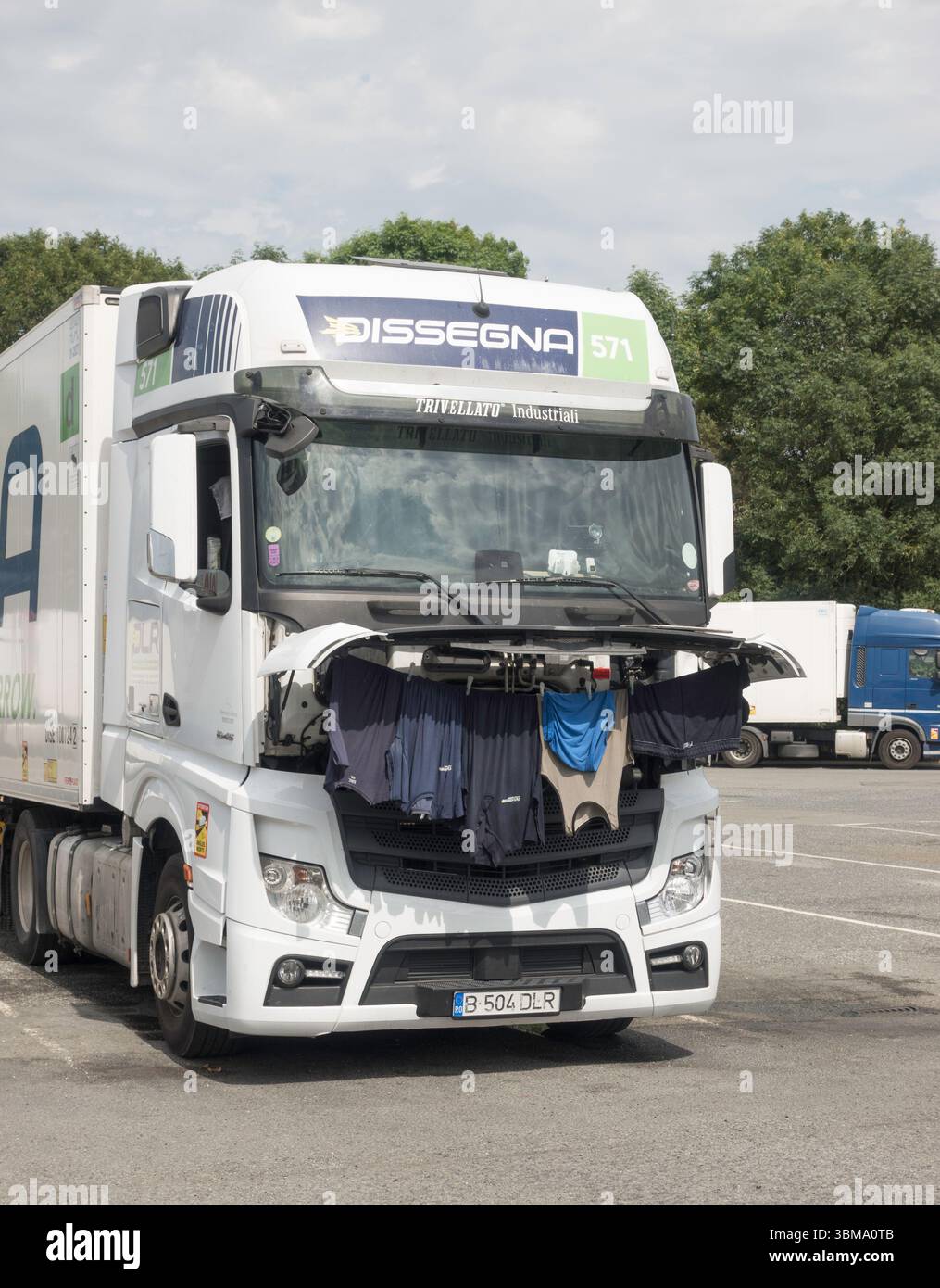 Ein LKW-Fahrer trocknet seine gewaschene Kleidung an der Vorderseite seines Lastwagens, England, Großbritannien Stockfoto