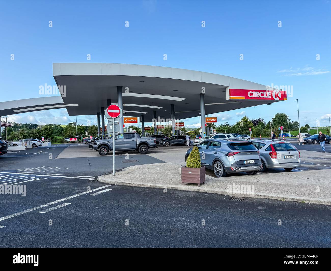 Barack Obama Plaza ist eine Autobahndienststelle und ein Einzelhandelszentrum an einem sonnigen Tag in Irland, an dem Autos und Menschen anwesend sind. Stockfoto