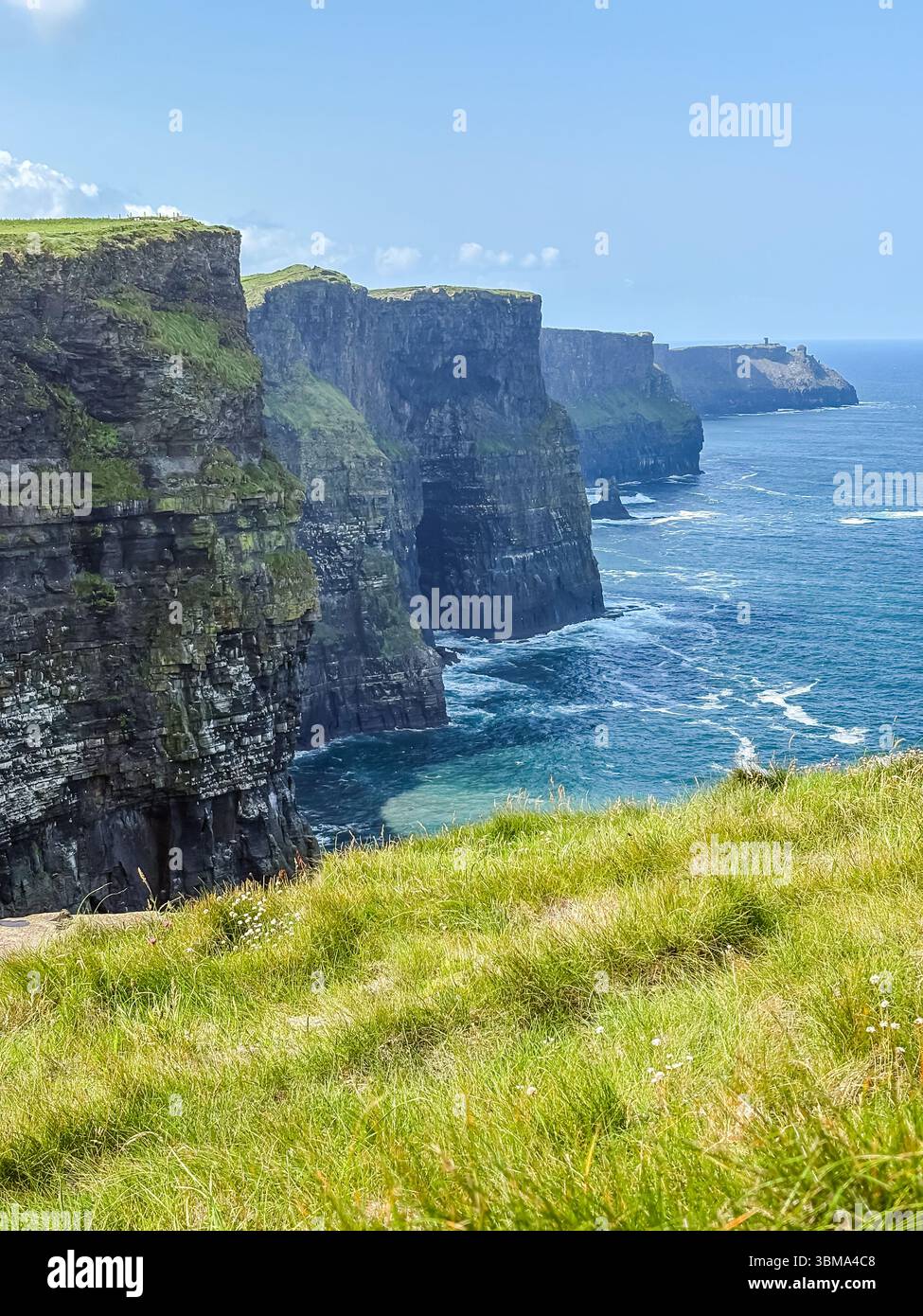 Cliffs of Moher. Dramatisch schroffe Küstenklippen und ein natürliches Wahrzeichen entlang der Atlantikküste Irlands mit grünem Gras im Vordergrund. Stockfoto
