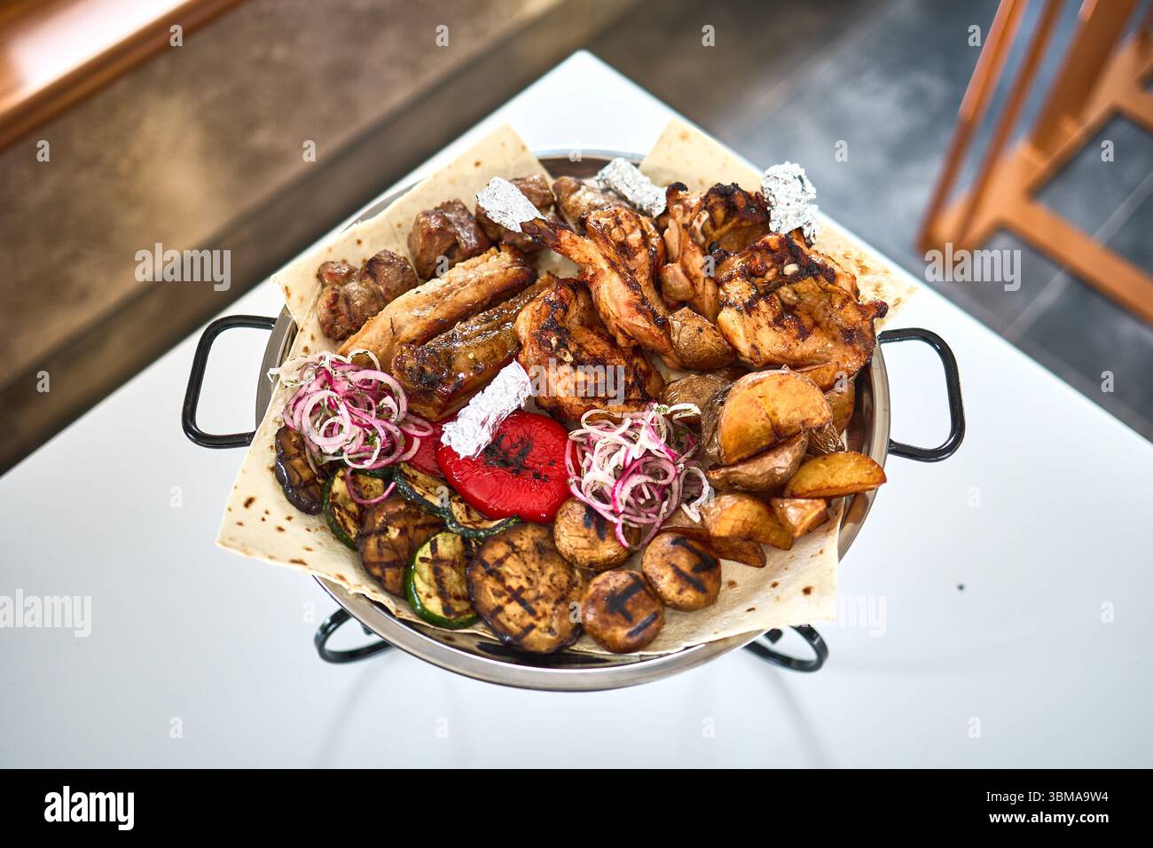 Gemischtes Grillfleisch mit Kartoffeln und Gemüse Stockfoto