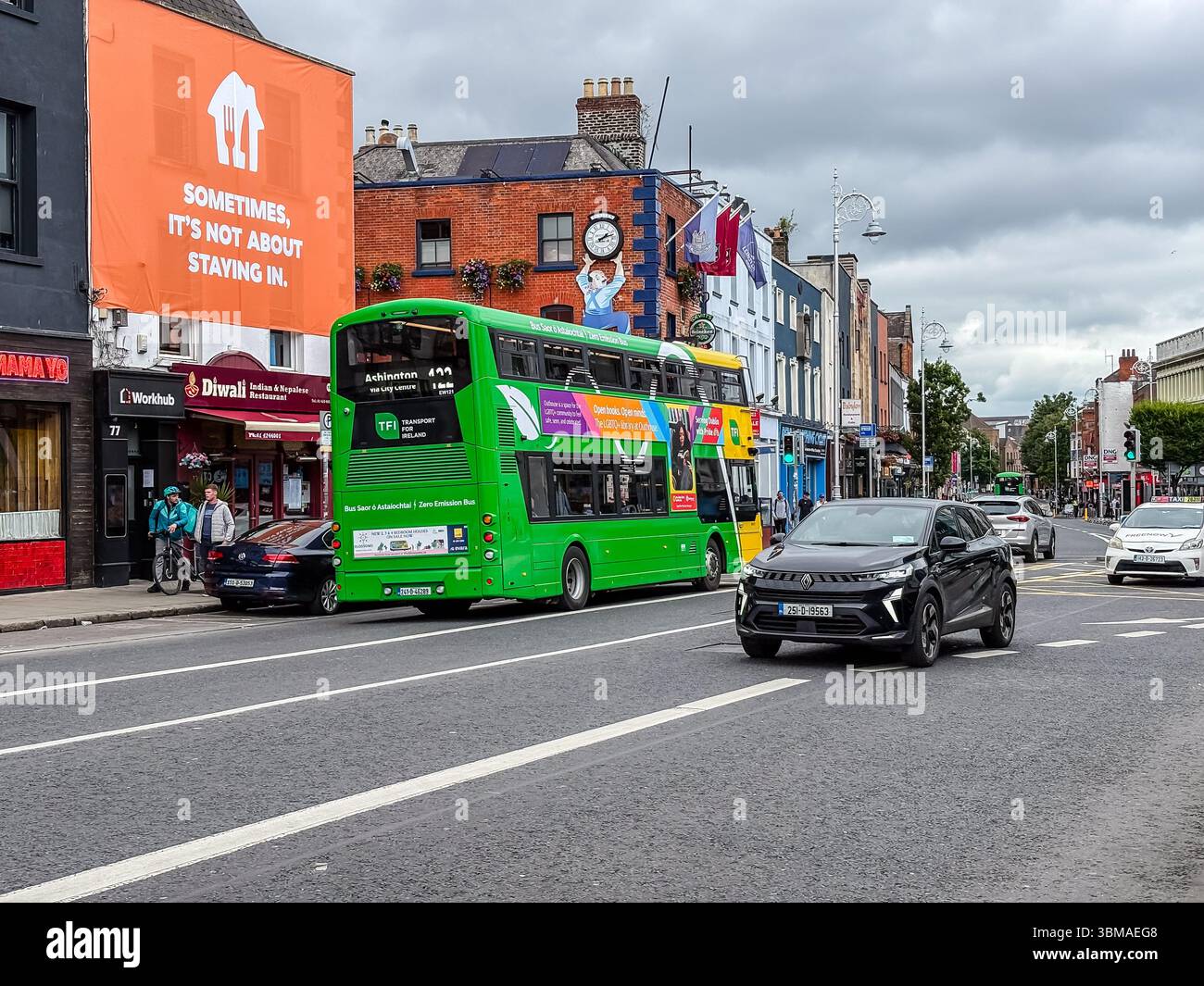 Lower Camden Street, Dublin. Blick auf die belebte Straße mit einem grünen Doppeldeckerbus, Autos, Fußgängern, Geschäften und Gebäuden. Stockfoto