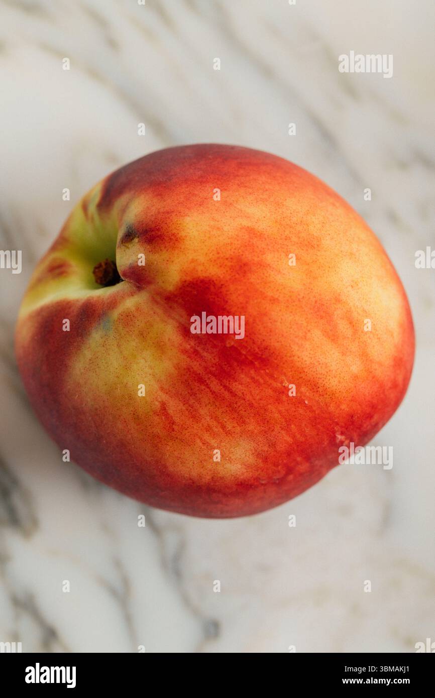 Weißer Pfirsich auf weißem Marmor Stockfoto
