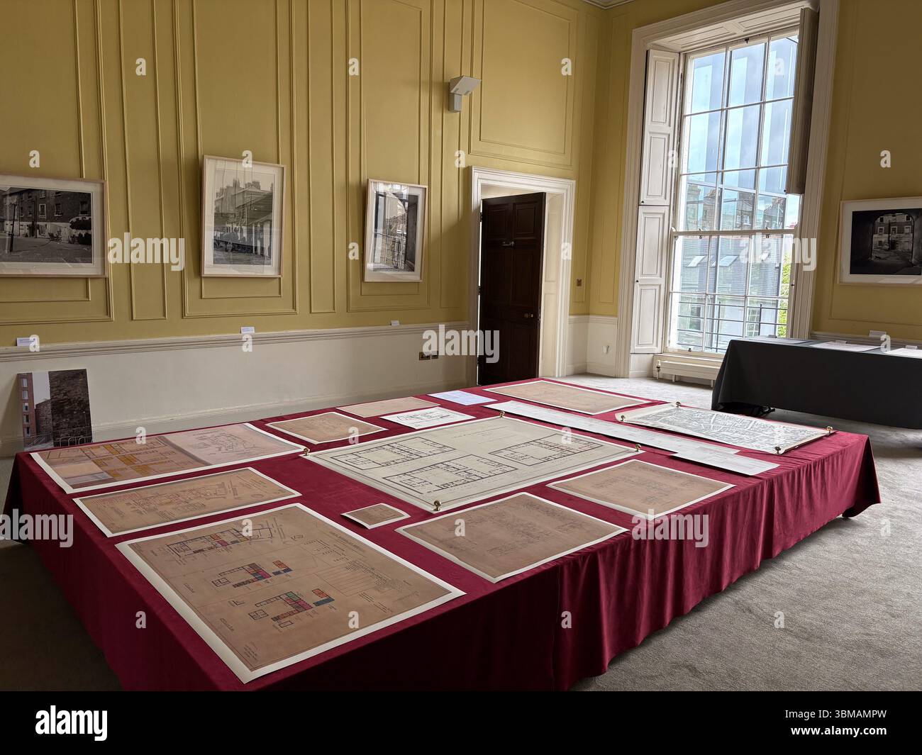 Das Irish Architectural Archive stellt Architekturpläne und Dokumente auf einem Tisch in einem Raum mit hohen Fenstern und gerahmten Bildern in Dublin aus. Stockfoto