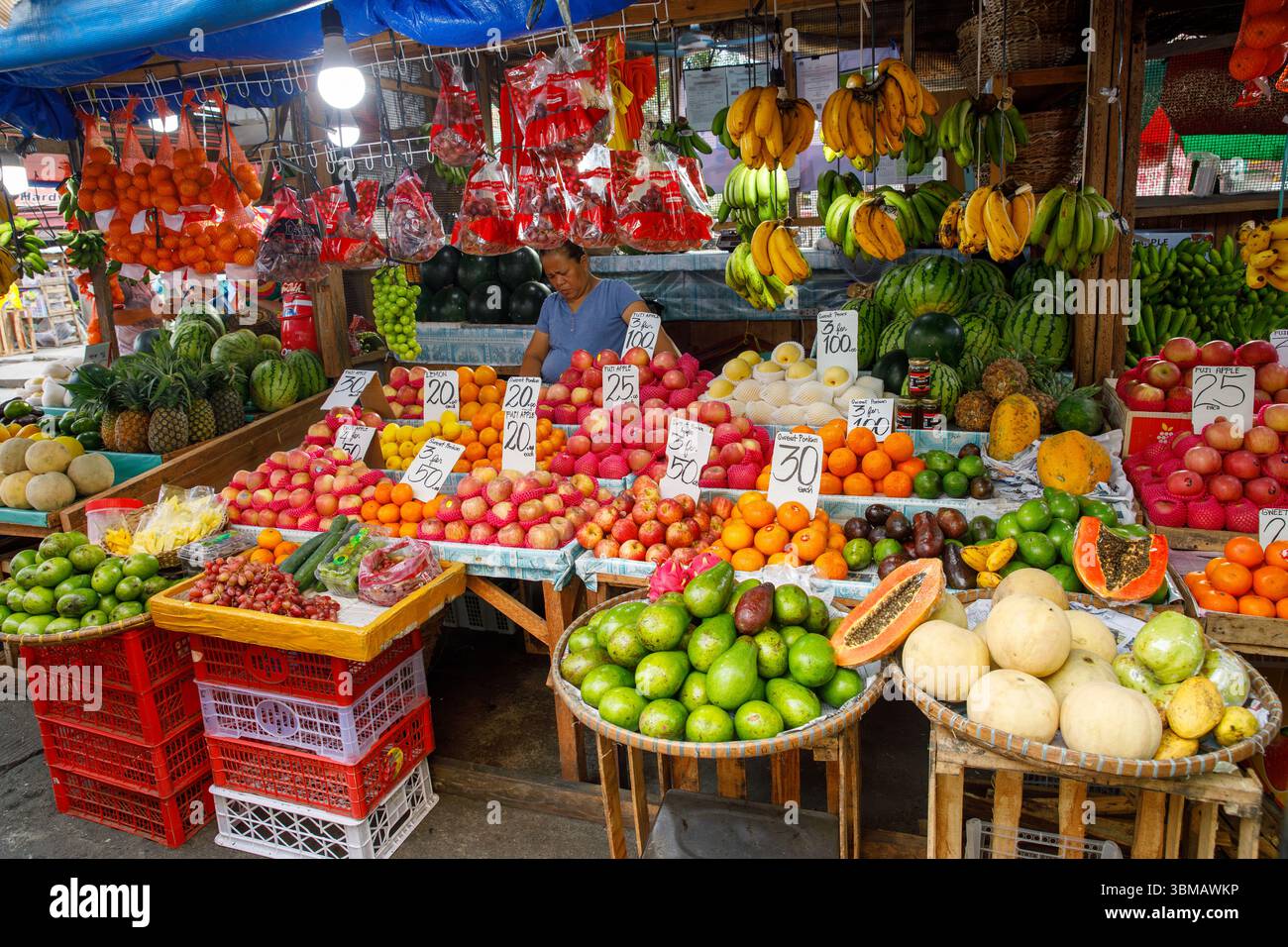 13. Mai 2025: Calapan City, Philippinen, farbenfroher tropischer Obstmarkt mit Verkäufern und Preisen Stockfoto