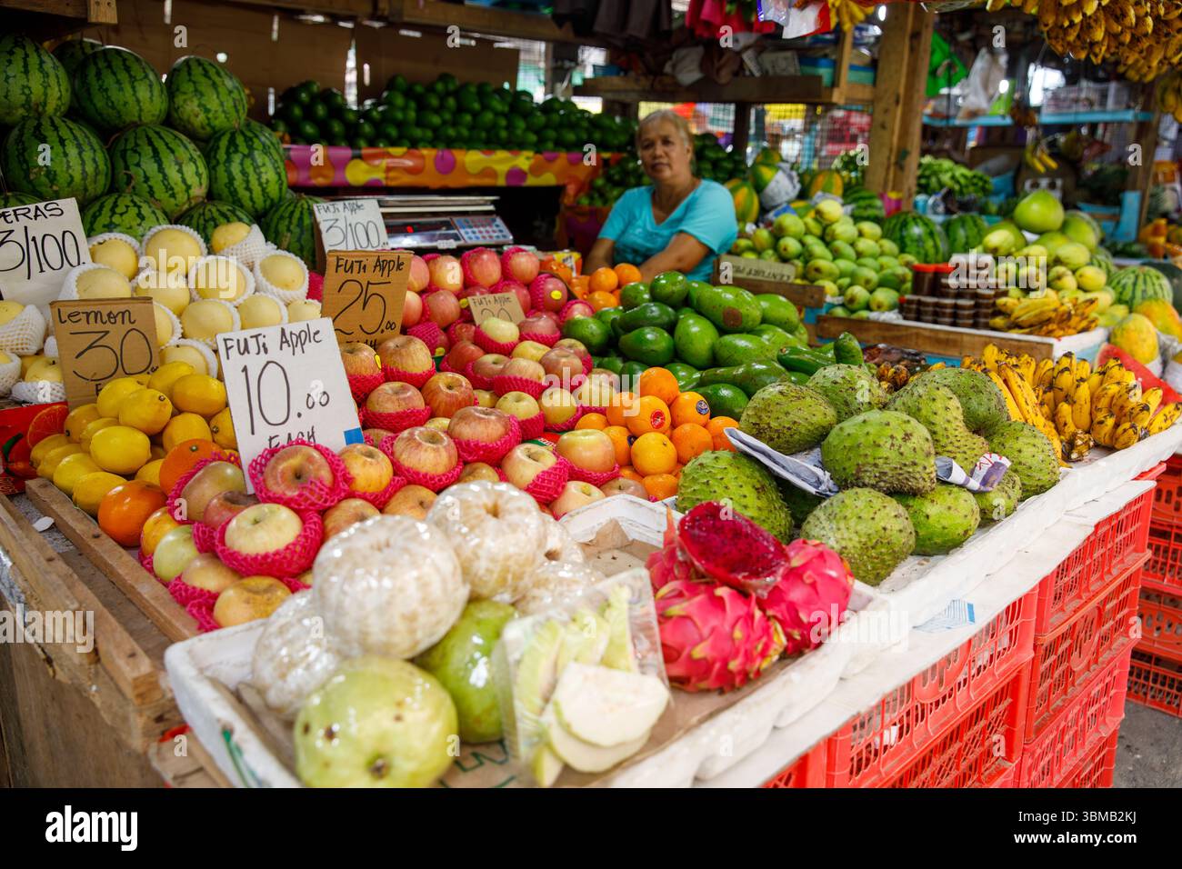 13. Mai 2025: Calapan City, Philippinen, Verkäuferin mit Äpfeln Zitronen Orangen Guavas und Drachenfrüchten auf dem lokalen Markt Stockfoto