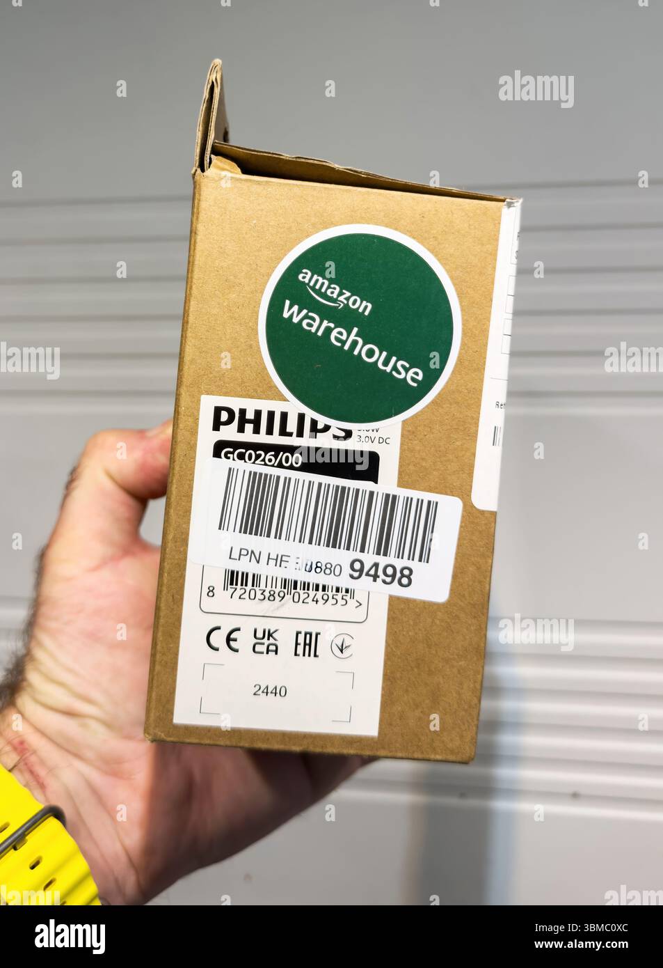 Ulm, Deutschland – 6. Mai 2025: Eine Hand hält eine Philips GC026 Box mit Amazon Warehouse Aufkleber, Strichcode-Etiketten und Zertifizierungssymbolen, die an ein s gesetzt sind Stockfoto