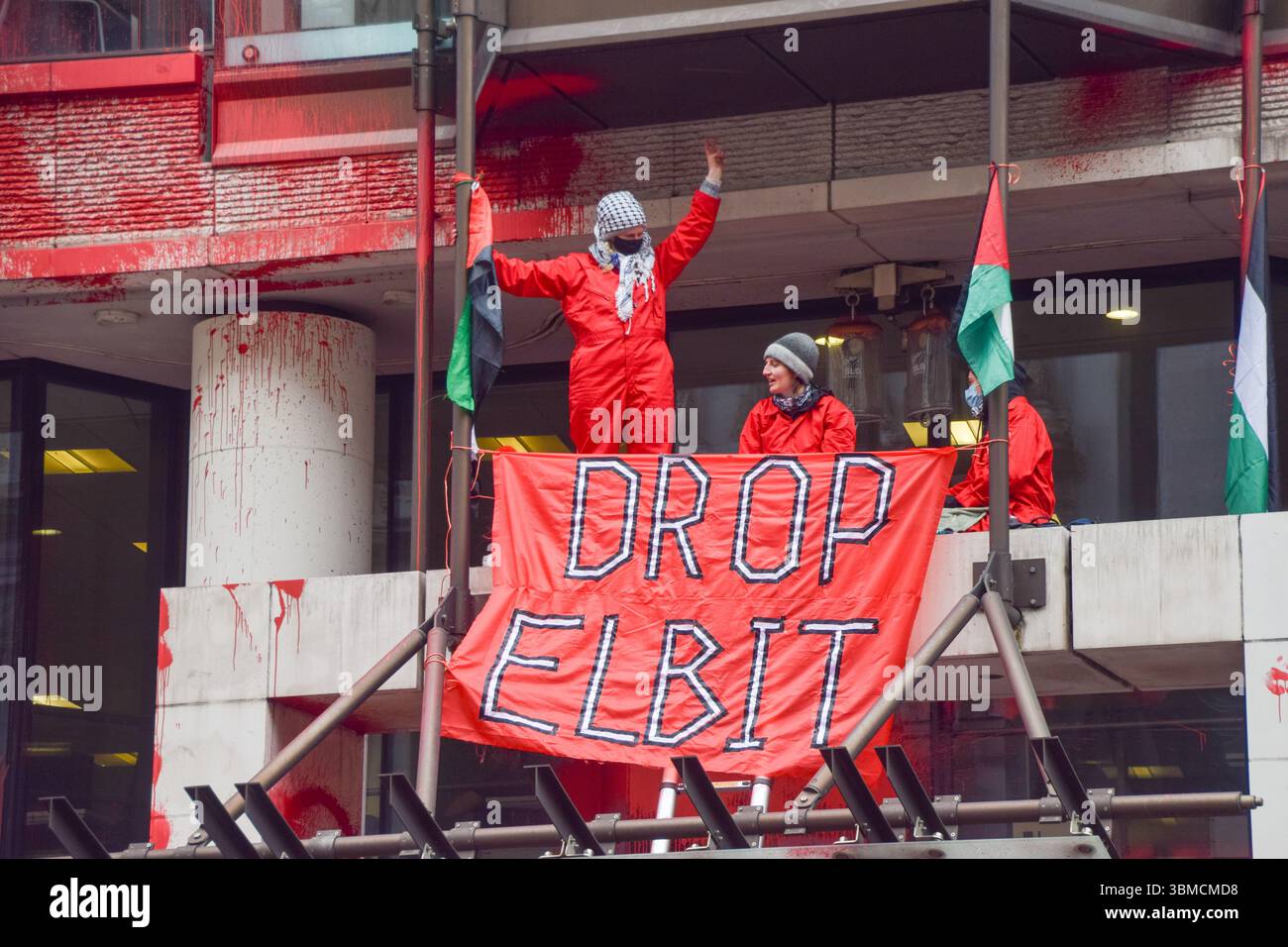London, Großbritannien. März 2025. Aktivisten der Gruppe Palestine Action klettern auf den Eingang der Allianz-Büros in der City of London, nachdem sie das Gebäude mit roter Farbe besprüht haben. Die Aktivisten rufen den Versicherungsriesen auf, Verbindungen zum Waffenunternehmen Elbit Systems zu unterbrechen. Quelle: Vuk Valcic/Alamy Live News Stockfoto