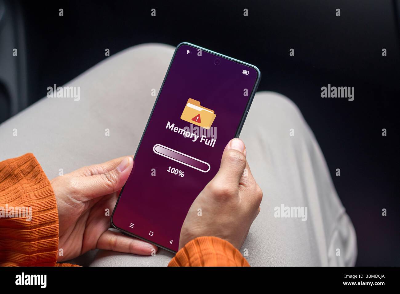 Frau, die ein Smartphone hält, mit voller Speicherkapazität auf dem Telefonbildschirm Stockfoto