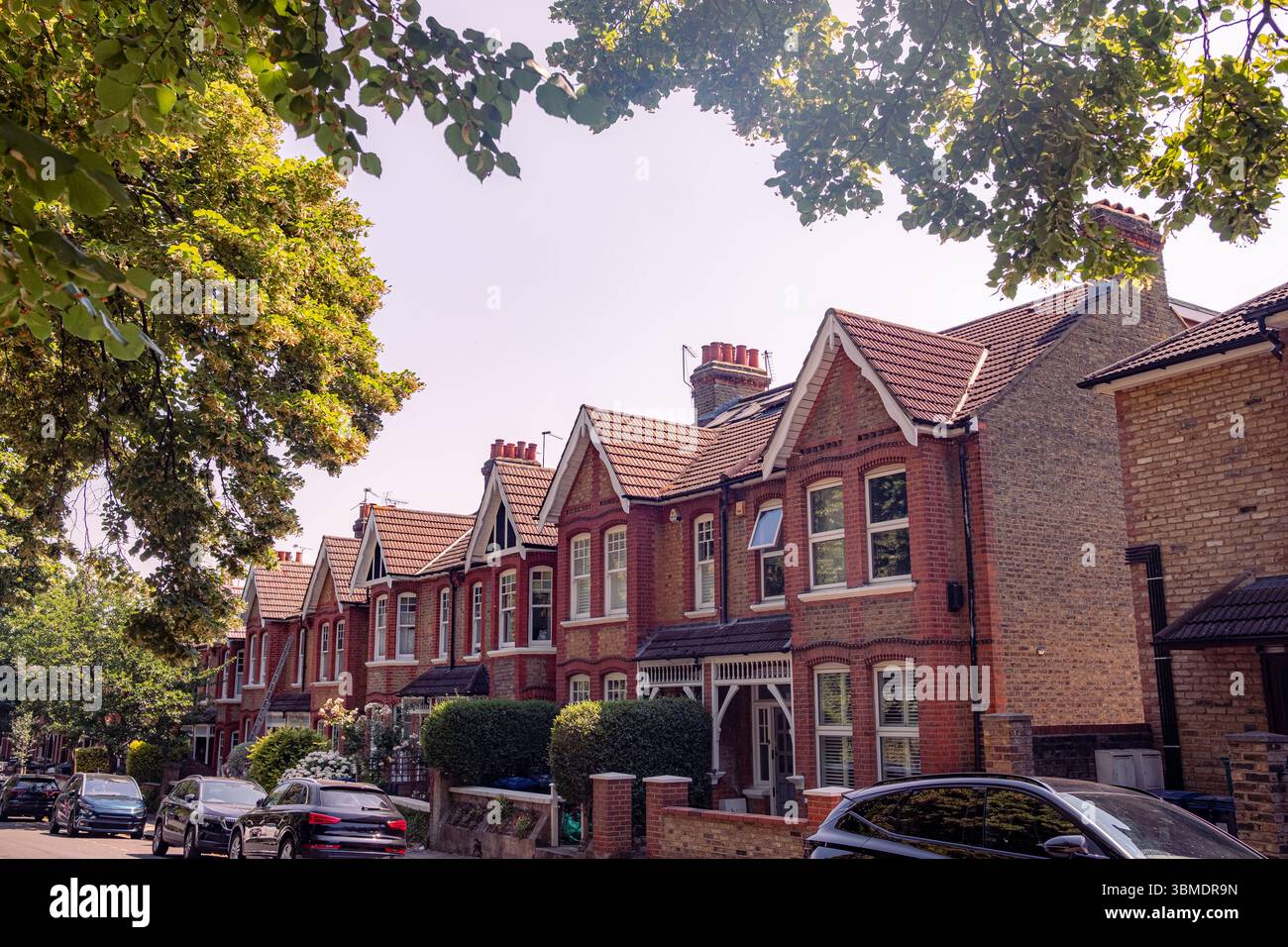 Typische Straße mit britischen Terrassenhäusern aus rotem Backstein in Ealing, außerhalb Londons Stockfoto