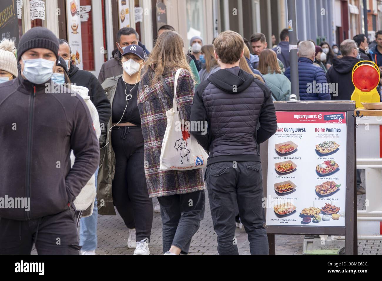Menschen, teilweise maskiert, in der Fußgängerzone von Heidelberg an einem Sonntag. Geschäfte sind wegen der Corona-Pandemie geschlossen, Heidelberg, Baden-Württemberg, Stockfoto
