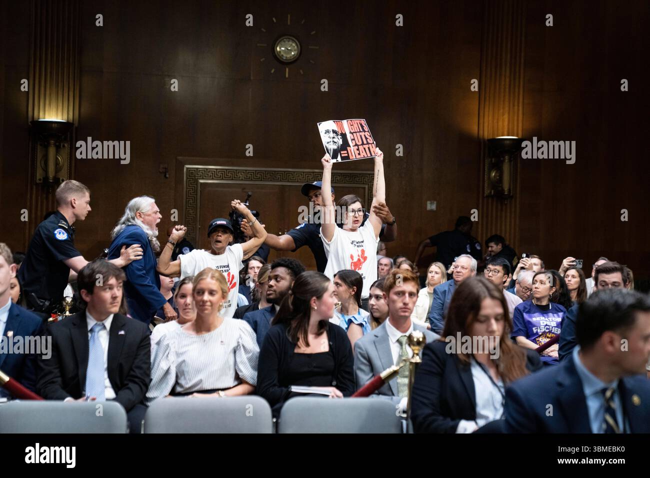 Die Demonstranten werden von der Capitol Police der Vereinigten Staaten aus dem Raum entfernt, als Russell Vought, Direktor, Office of Management and Budget (OMB), während der Anhörung des US-Senatsausschusses für Mittel Zeugenaussagen gab, um die Sonderbotschaft des Präsidenten vom 3. Juni 2025 im Dirksen Senate Office Building auf dem Capitol Hill in Washington, DC, USA, am Mittwoch, den 25. Juni, zu prüfen. 2025.Credit: Andrew Thomas/CNP /MediaPunch Stockfoto