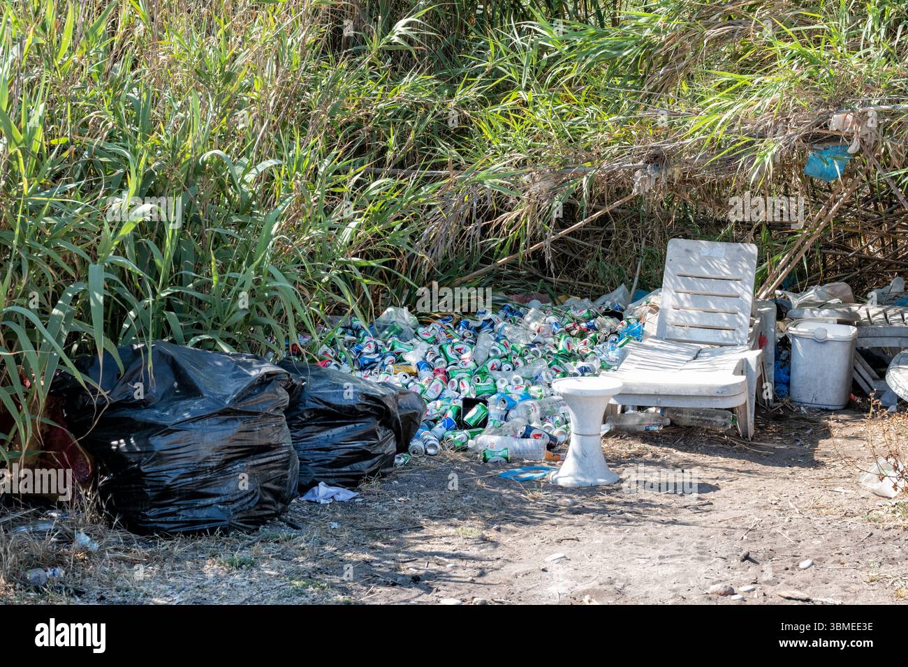Rhodos, Griechenland. Ein Sammelhaufen Müll, der an einem Strand abgelegt wurde. Auf dem Haufen auf der Rückseite des Strandes befinden sich zahlreiche Getränkedosen und kaputte Möbel Stockfoto