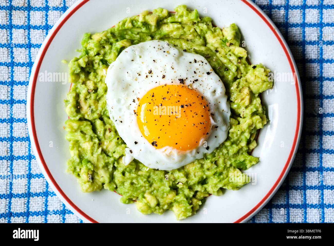 London UK June 26 2025, gesundes gebratenes Ei auf püriertem Avocado-Mahl Stockfoto