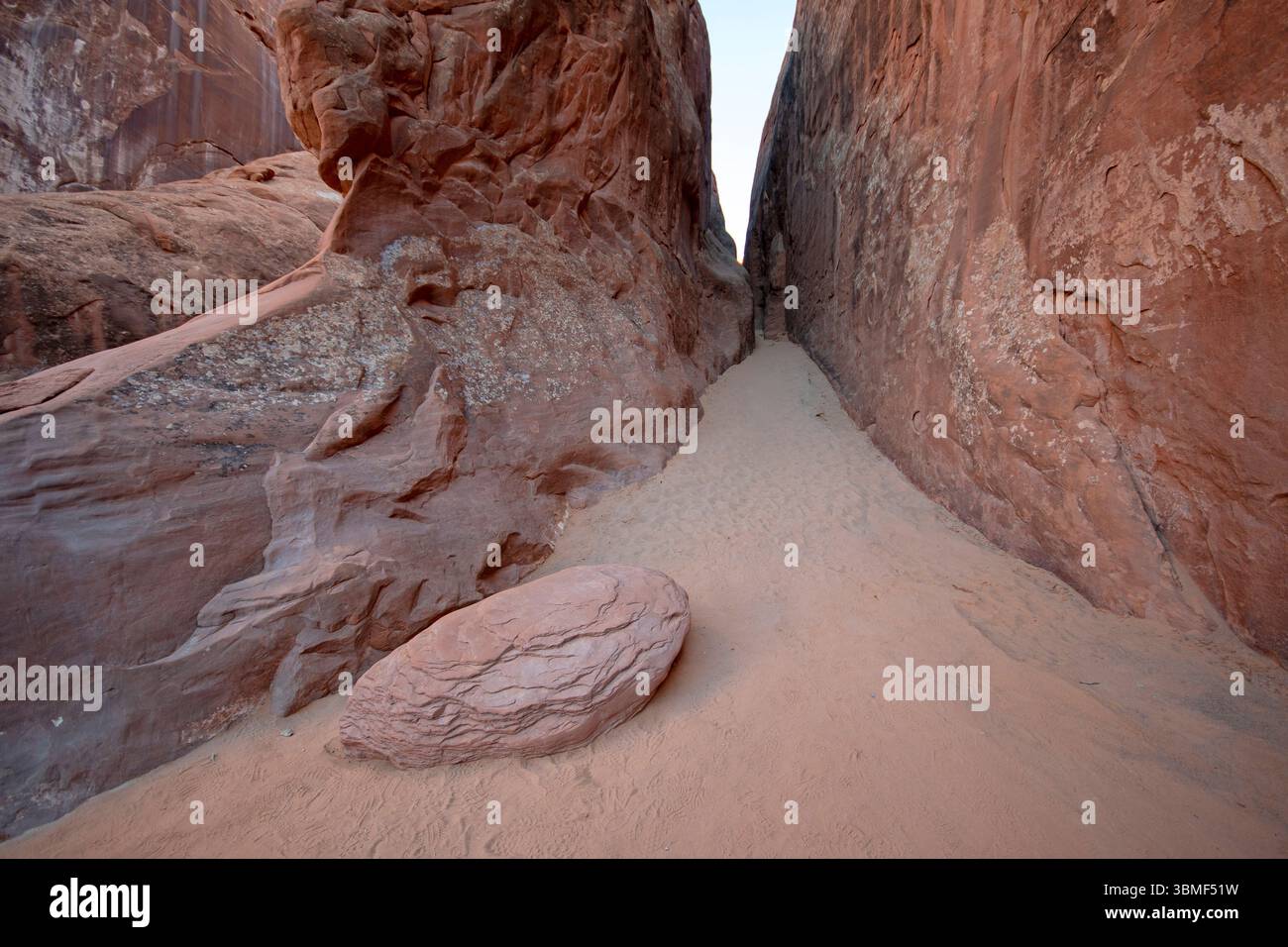 Sandiger Pfad zwischen schmalen Felswänden entlang des Devils Garden Trail im Arches National Park, Utah, USA Stockfoto