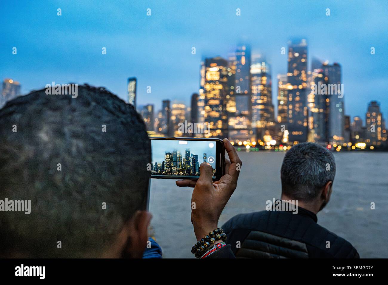 Touristen im Urlaub machen Architekturfotos von den Wolkenkratzern der Skyline von New York City auf einer Hudson River Bootstour verregneter NYC Urlaubstourismus Stockfoto