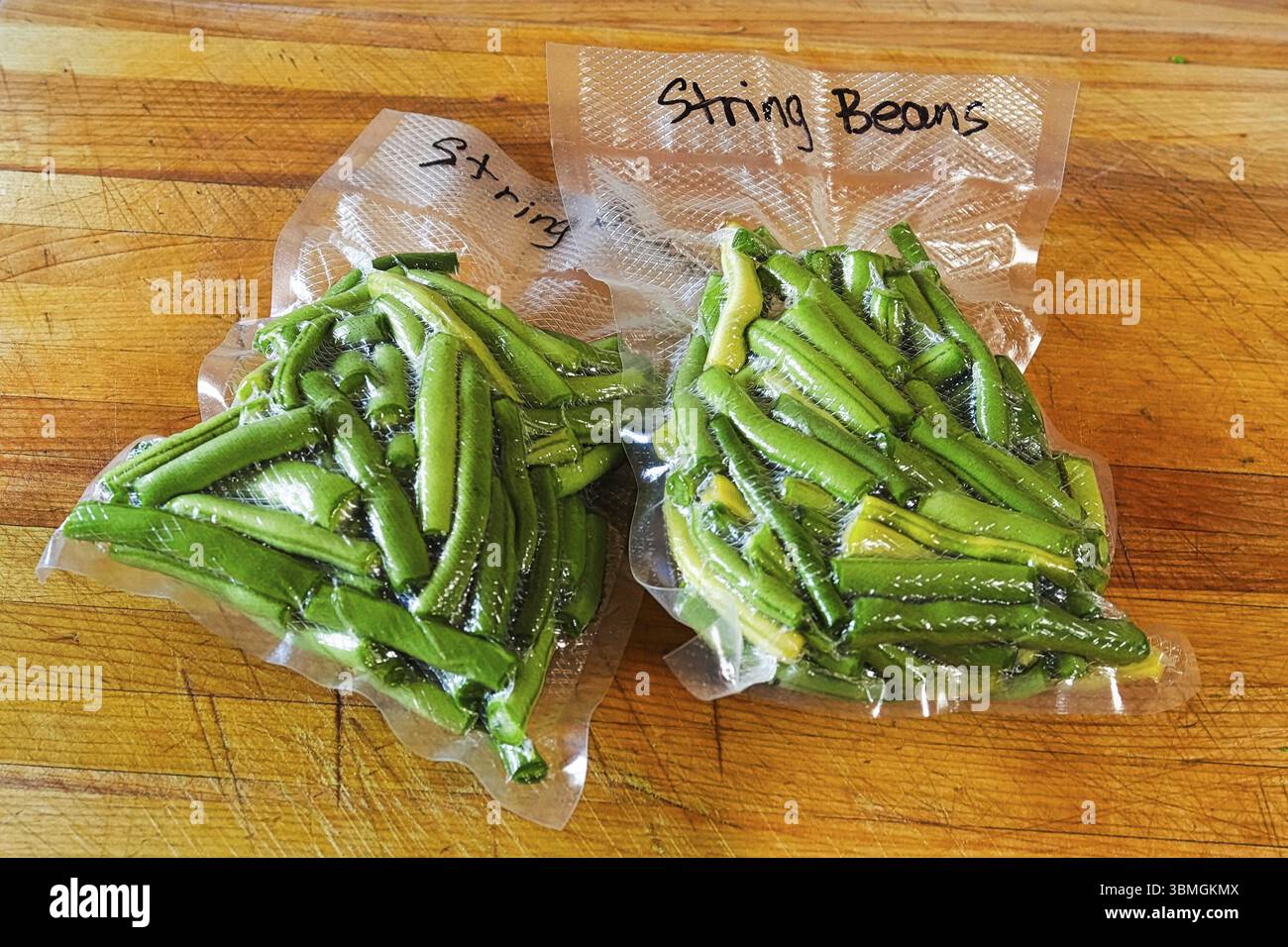 Zwei Pakete frische grüne Bohnen vakuumversiegelt in Beutel Stockfoto