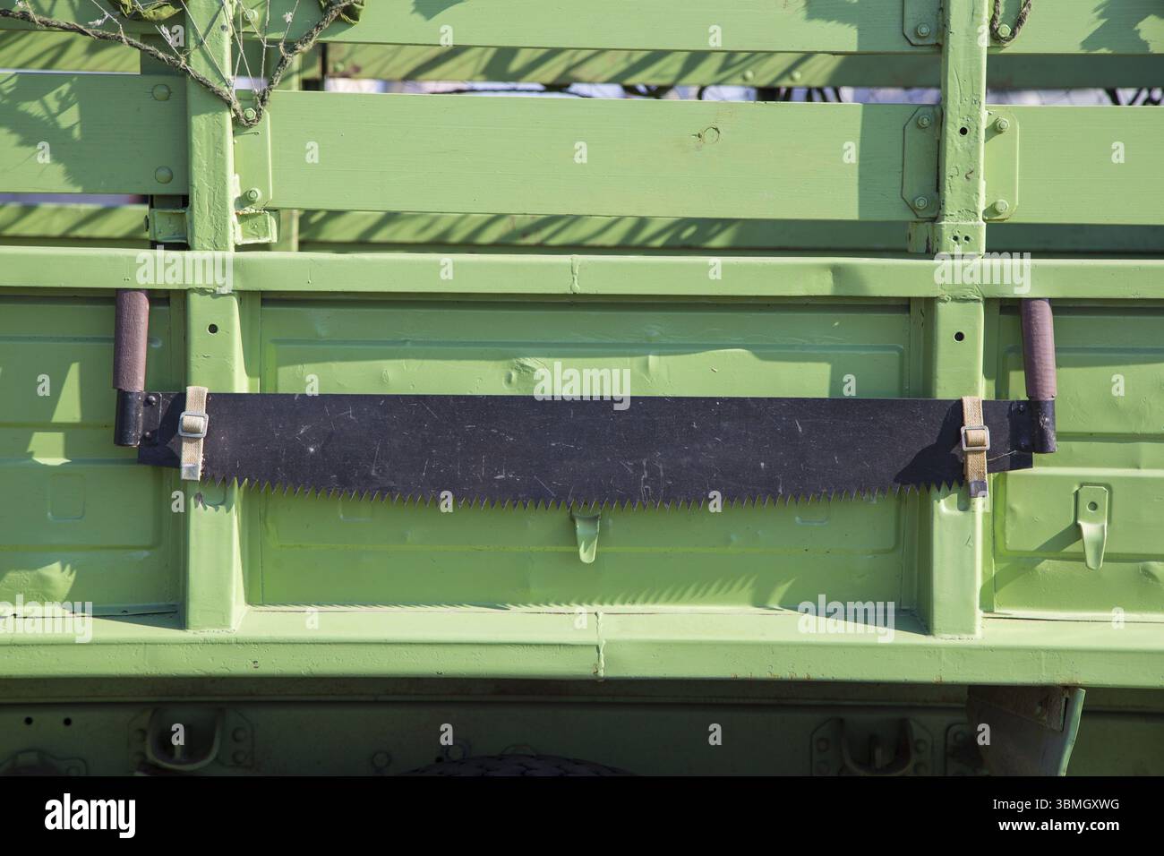 Handsäge an Bord eines Militärfahrzeugs. Militärisches Konzept. Klassische Zweimannsäge Stockfoto