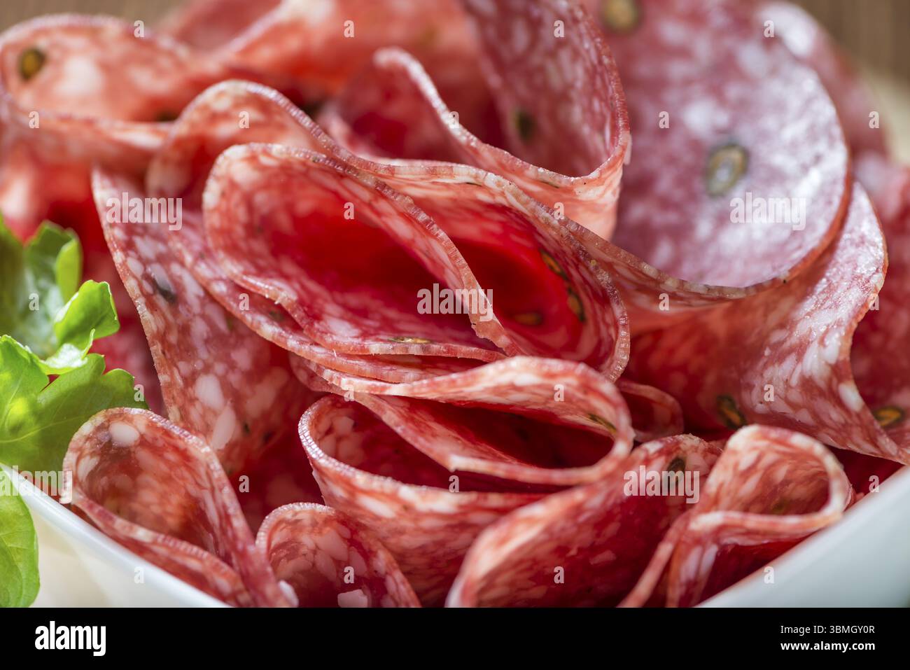 Scheiben Salami (Tiefenschärfe) auf einem alten Holztisch vintage Stockfoto