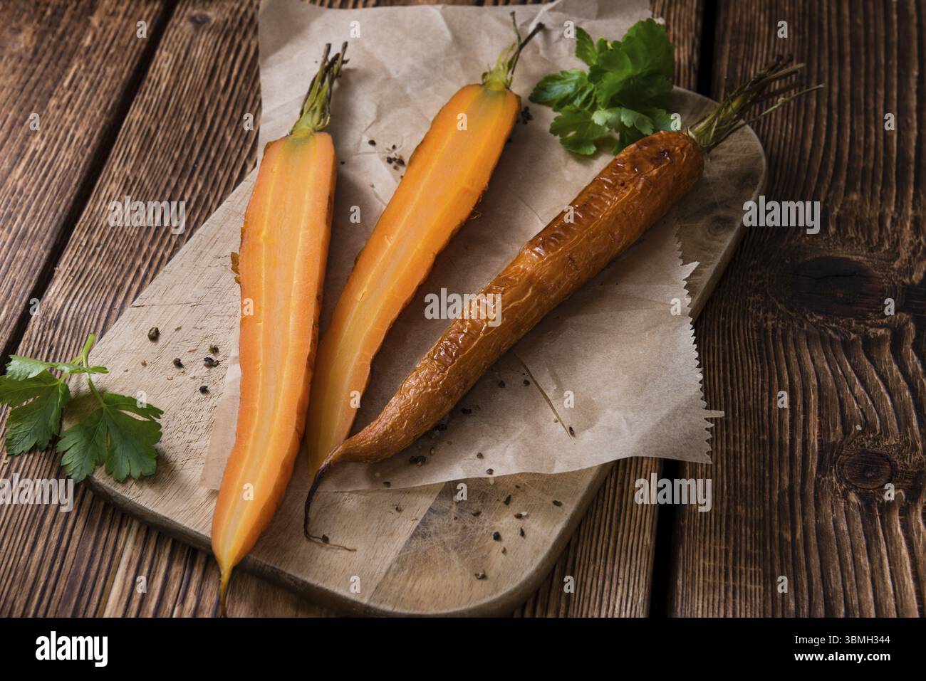 Portion gebackene Karotten (Nahaufnahme) auf einem alten Vintage-Hintergrund Stockfoto