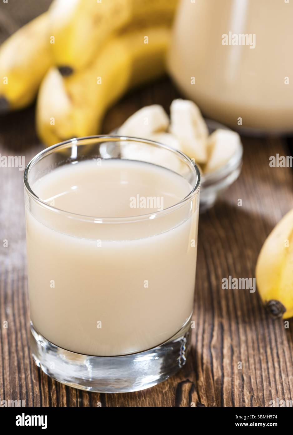 Frisch gemacht Bananensaft in einem Glas (auf hölzernen Hintergrund) Stockfoto
