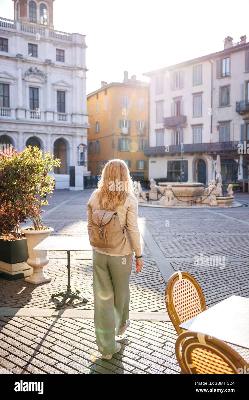 Reisende, die während der Sommerferien eine friedliche Morgenatmosphäre auf dem Piazza Vecchia in Bergamo, Italien, genießen. Alleinreiseurlaub Stockfoto