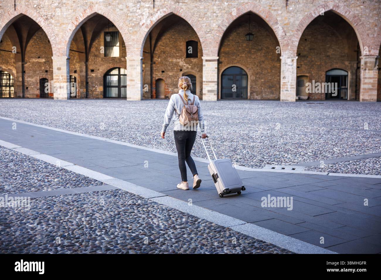 Frau mit Koffer, die in Citta Alta Oberstadt von Bergamo, Italien für Urlaub ankommt. Alleinreiseabenteuer in Europa Stockfoto