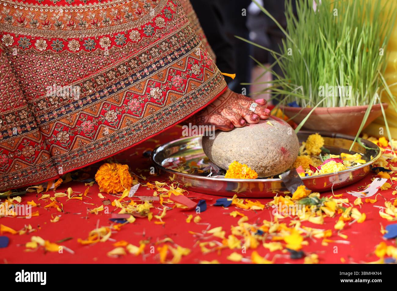 Shila Arohan oder Shilarohan-Ritual fand hauptsächlich indische Hochzeiten statt. Der mit Henna verzierte Fuß der Braut (mehndi) wird auf einem Schleifstein/Shilbatta platziert. Stockfoto