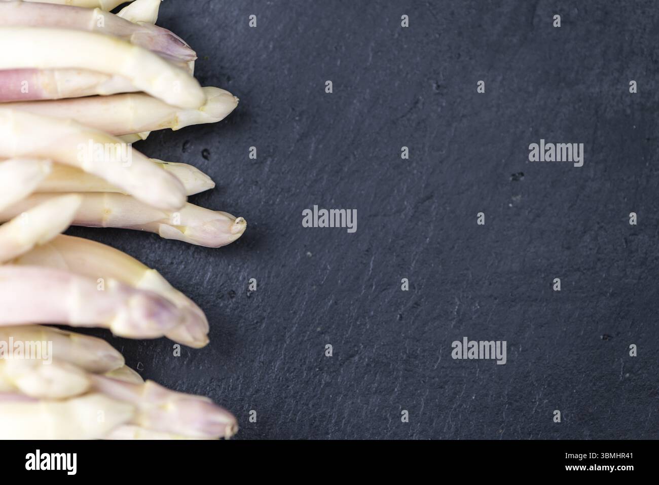 Weißer Spargel (Nahaufnahme) auf eine Schiefer-Tafel (Tiefenschärfe) Stockfoto