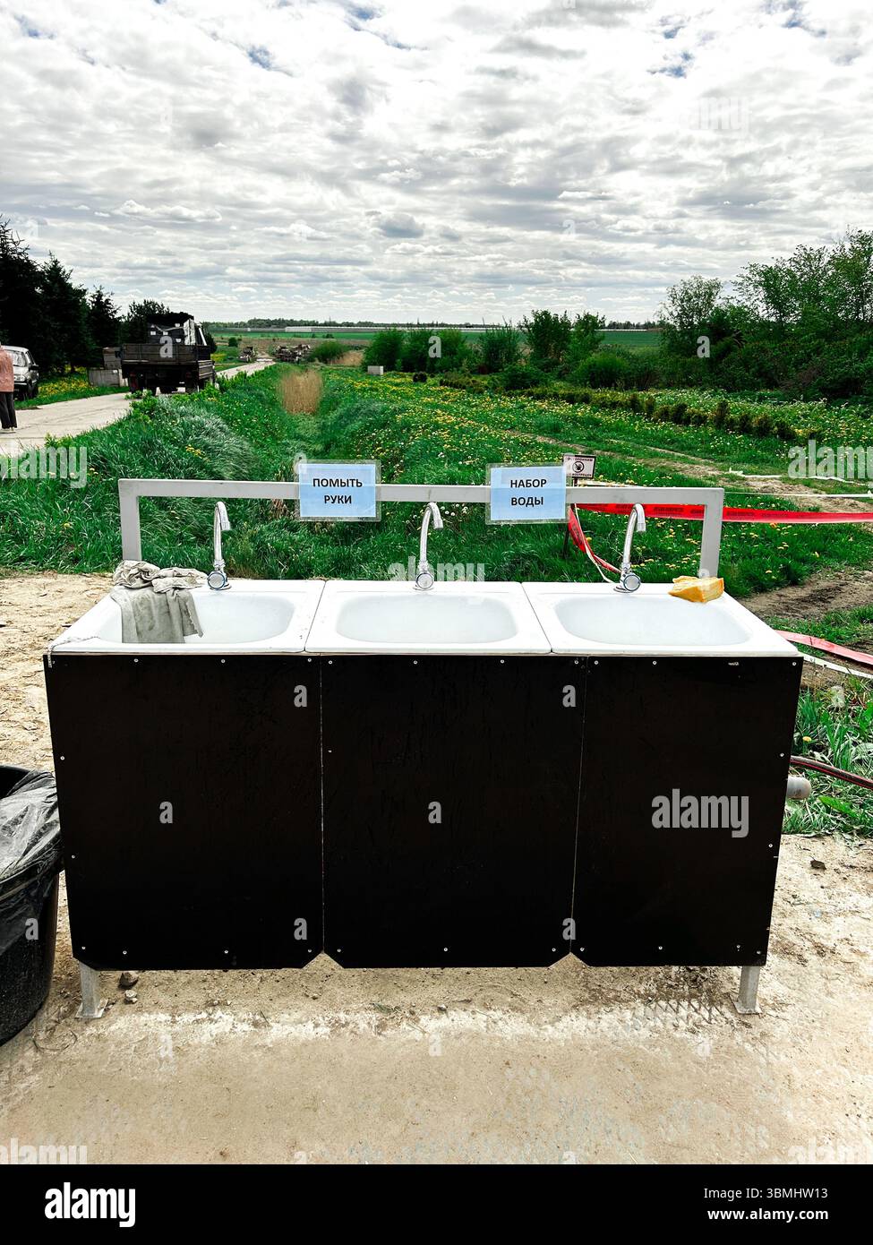 Handwaschstation mit drei Waschbecken mit Seife und Handtüchern im Freien. Hygiene und Gesundheitsbewusstsein Stockfoto