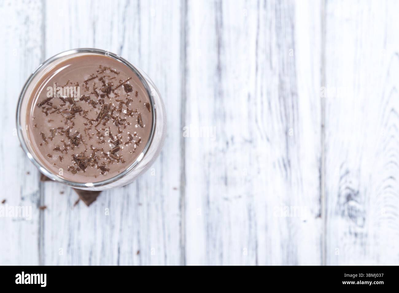 Kalte Schokoladenmilch trinken (Nahaufnahme) auf hölzernen Hintergrund Stockfoto