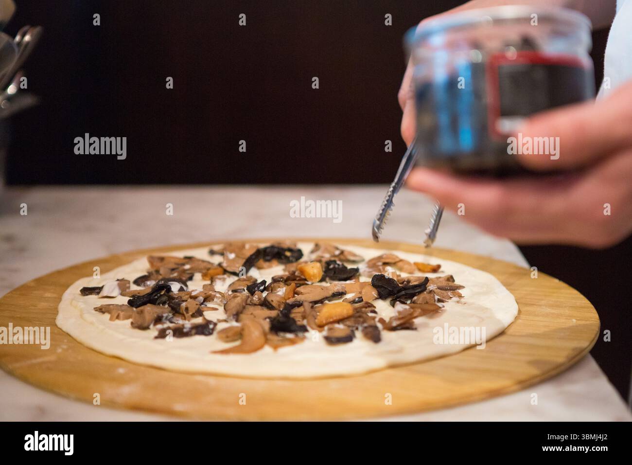 Ein Koch, der in Macau Feinschmeckerpizza zubereitet Stockfoto