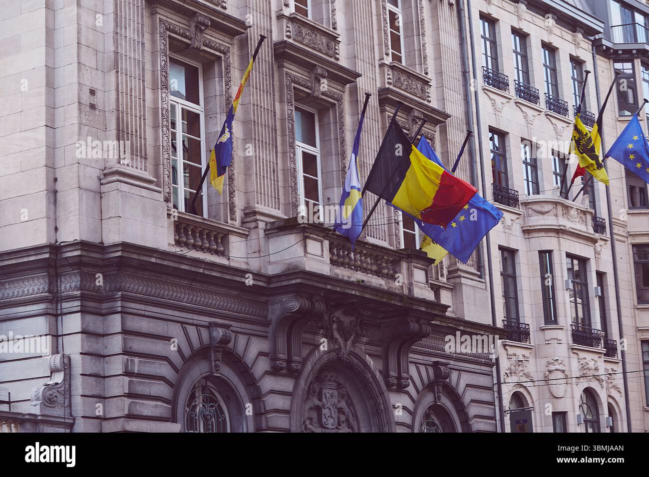 Brüsseler Straßen mit den Flaggen Belgiens, der EU und Regenbogenflaggen - ein Symbol der Vielfalt Stockfoto