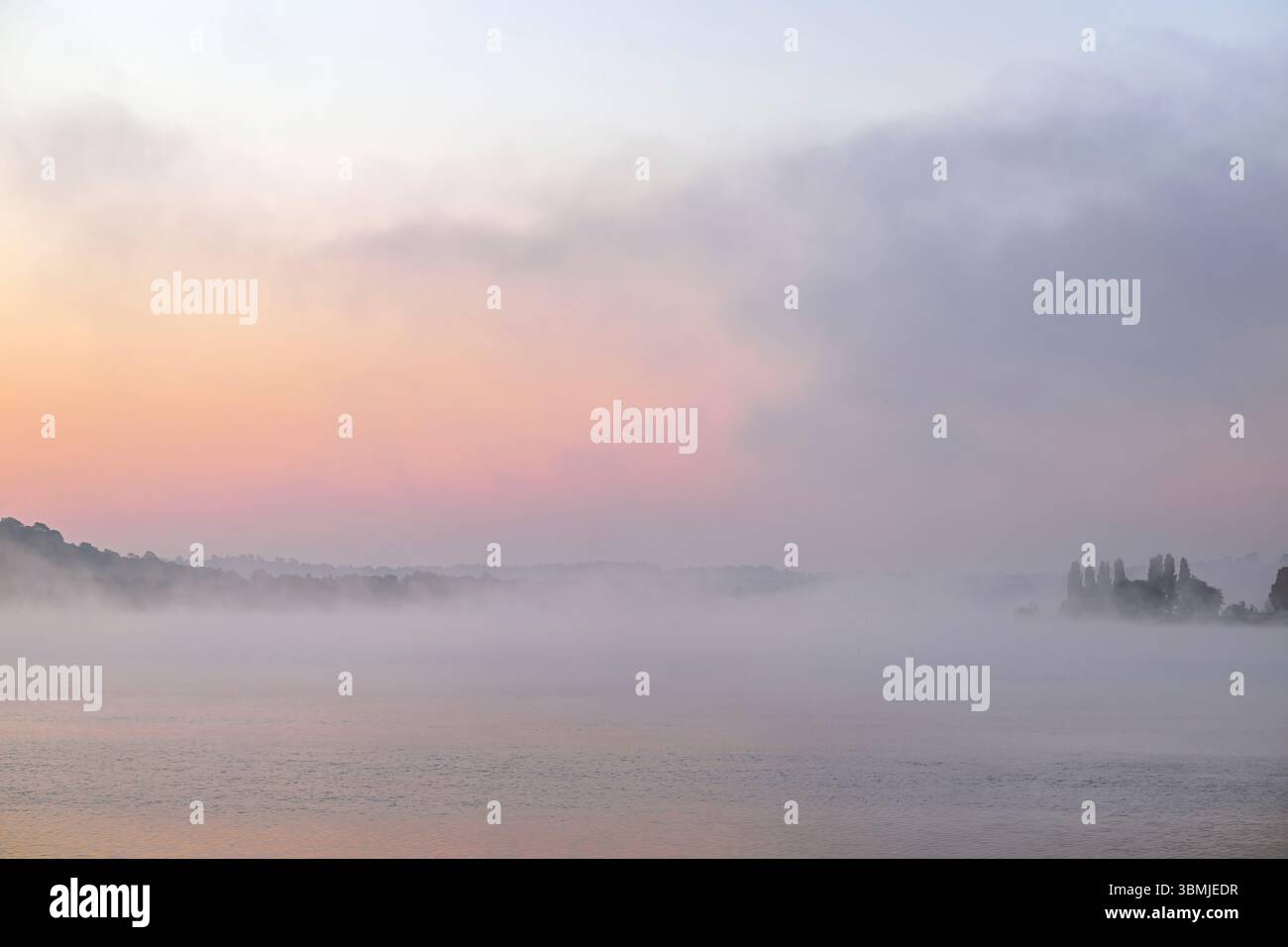 Blagdon Lake, Somserset bei Sonnenaufgang an einem sehr nebeligen Morgen im Frühling mit einem wunderschönen hellen Sonnenaufgang, der durch den Nebel zeigt Stockfoto