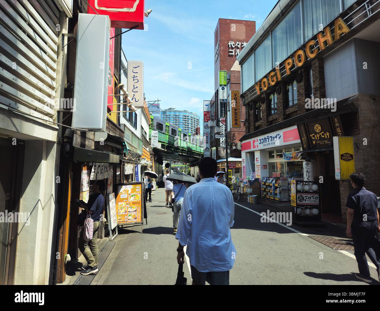 Straßenszene in Shibuya, Tokio - U-Bahn oben und geschäftige Geschäfte unten Stockfoto