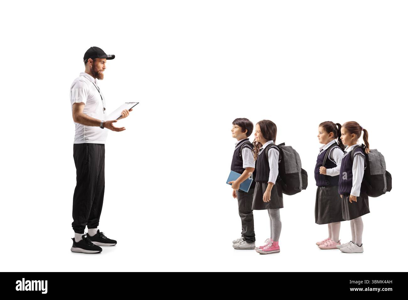 Sportlehrer, der mit einer Gruppe von Schulkindern auf weißem Hintergrund spricht Stockfoto